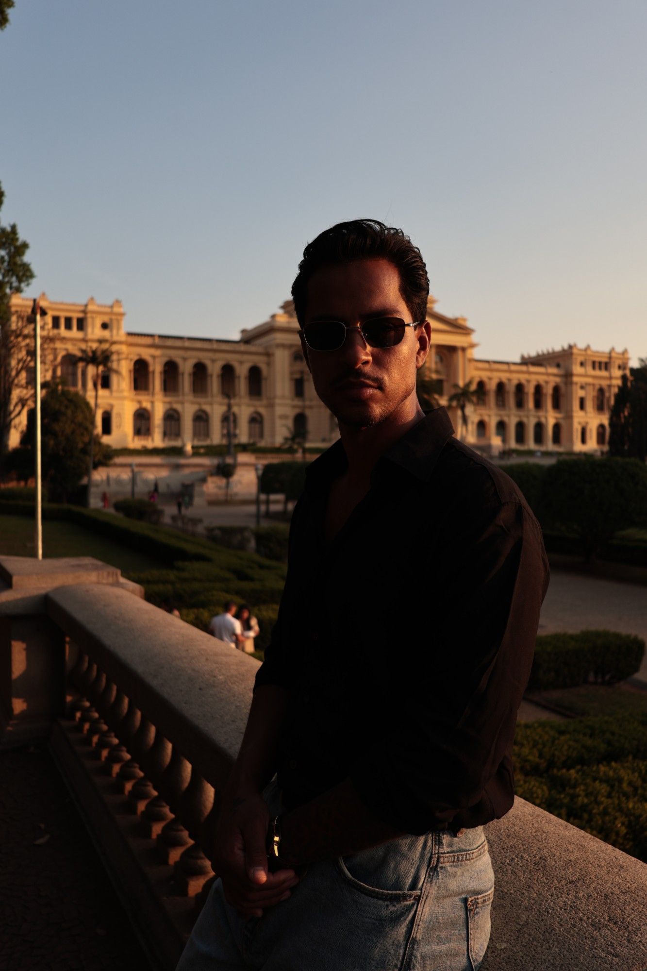 Retrato em contraluz diante de um palácio ao entardecer