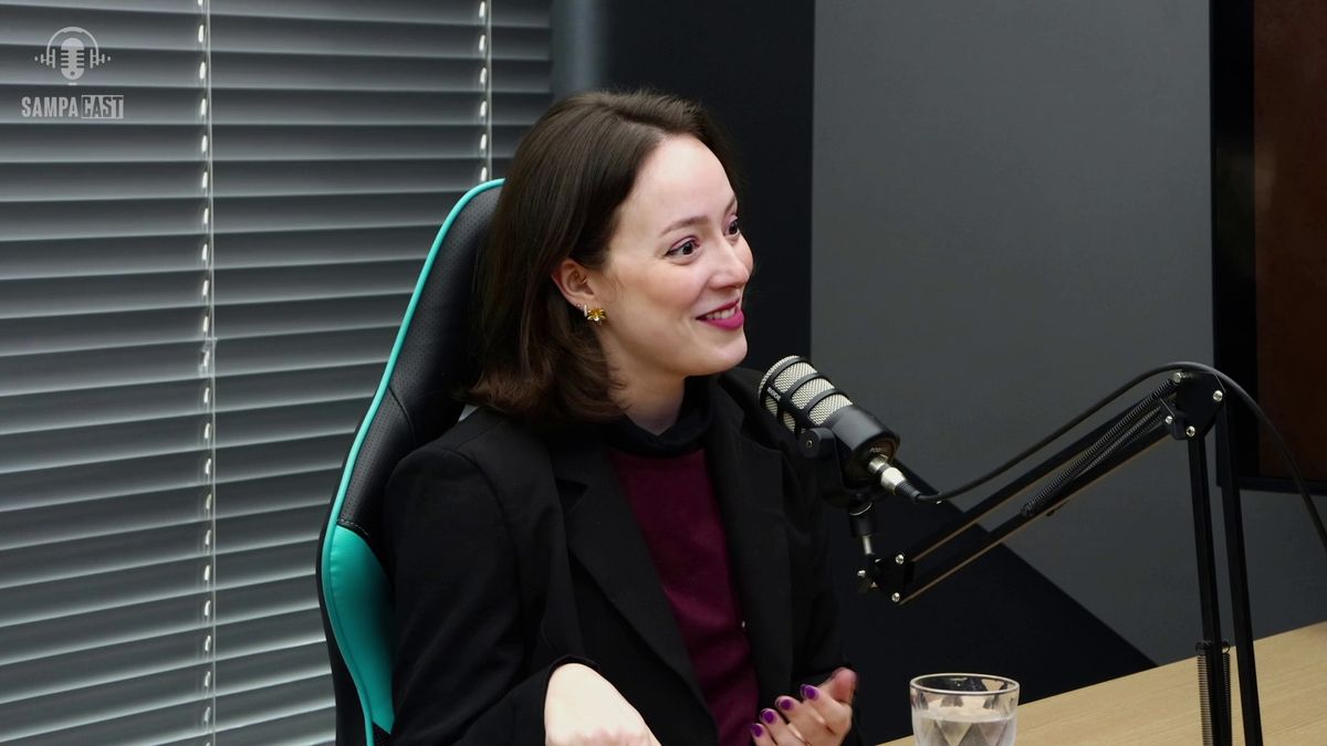 Apresentadora sorrindo diante do microfone de podcast