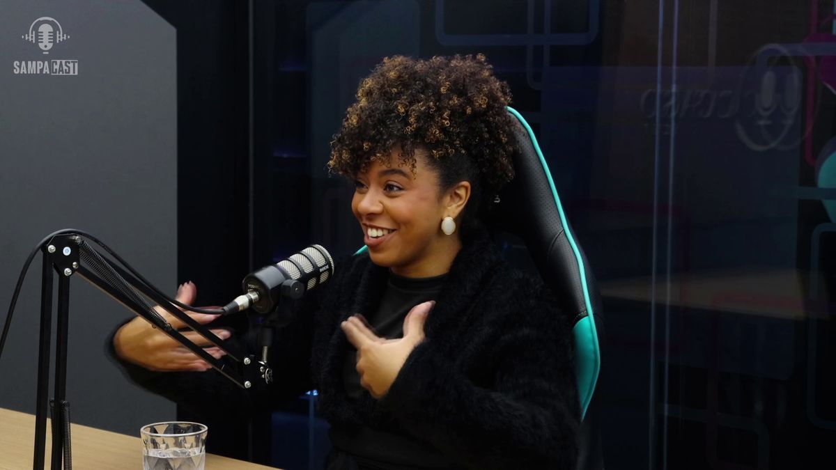 Convidada gesticulando e sorrindo no estúdio de podcast